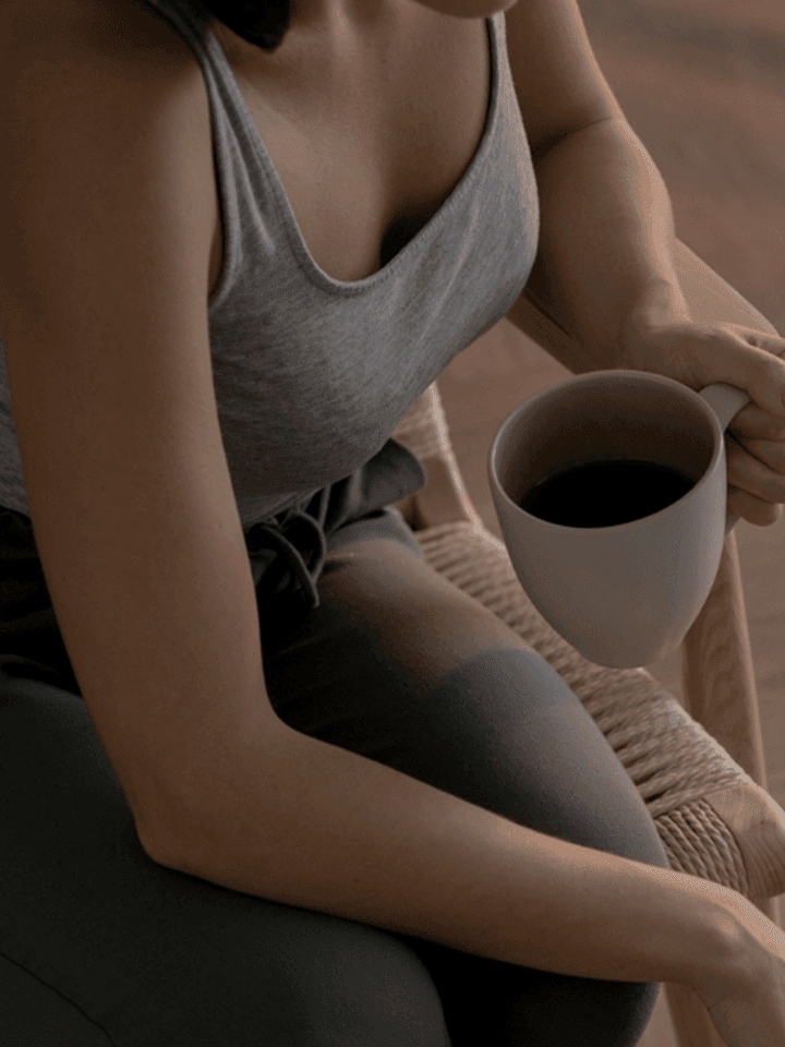 A woman sitting with a mug, back to everyday life after her screening