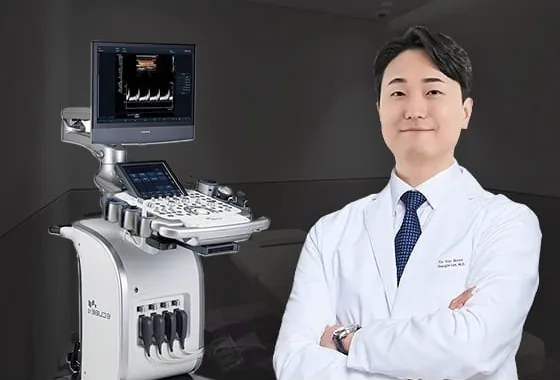 A breast-surgery specialist standing beside the ultrasound unit